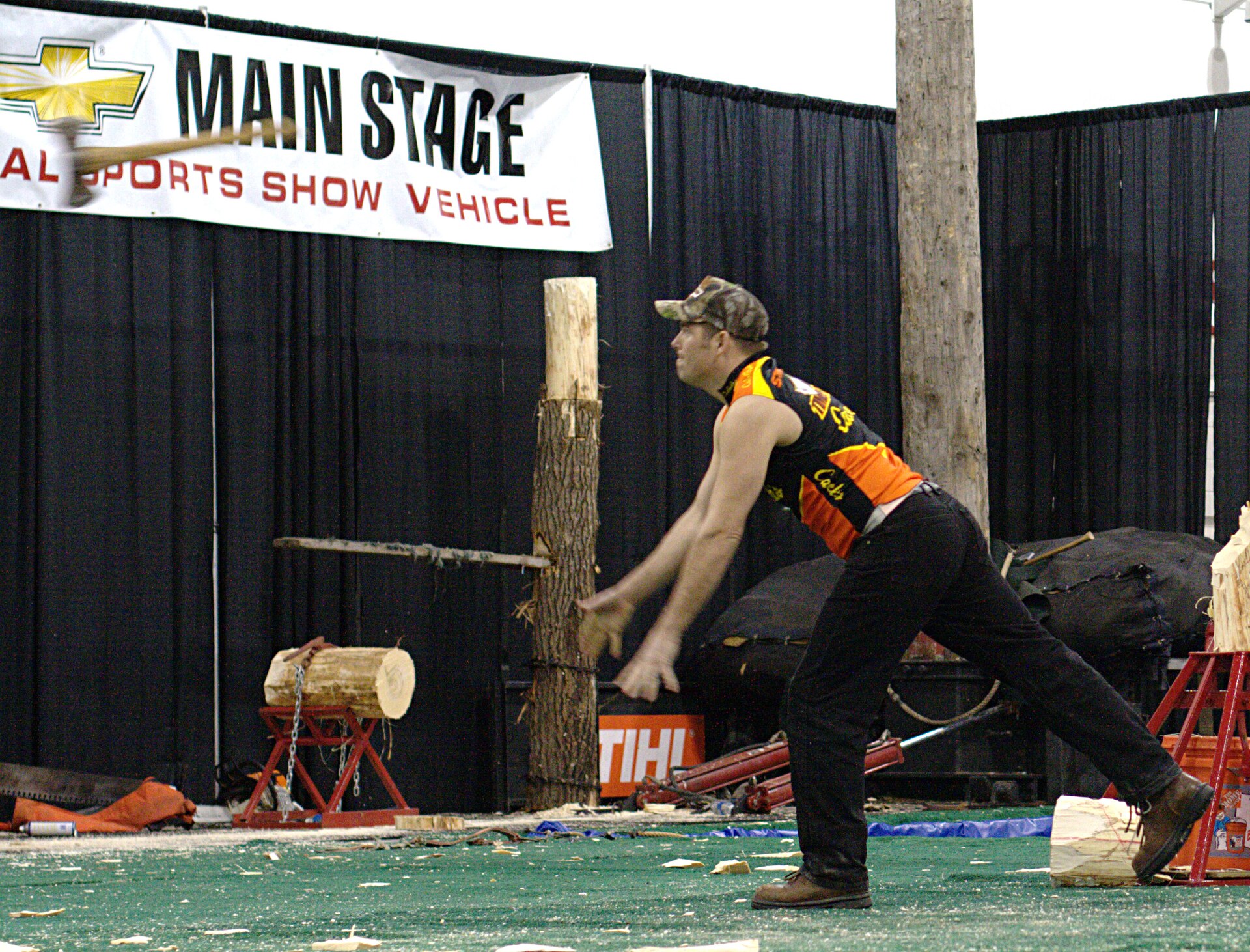Thrower releasing an axe toward a wooden target
